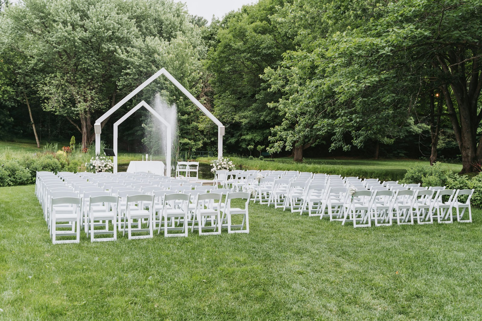 Yeşil bahçe içinde beyaz sandalye ve nikah alanı